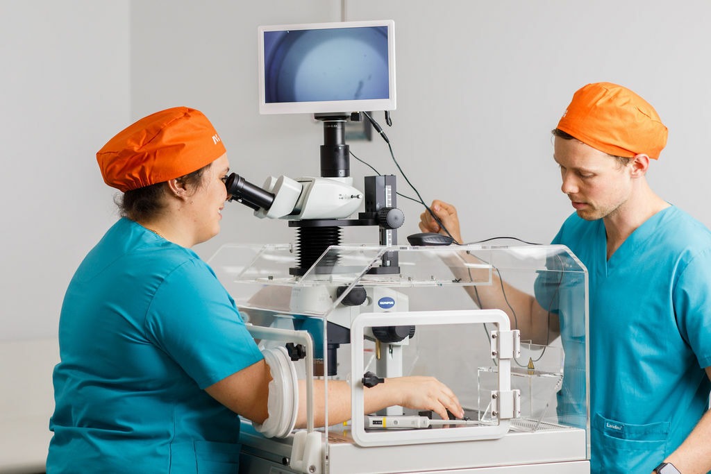 Fertility specialists performing an egg pick-up procedure using advanced lab equipment at ayuh fertility centre in ahmedabad.