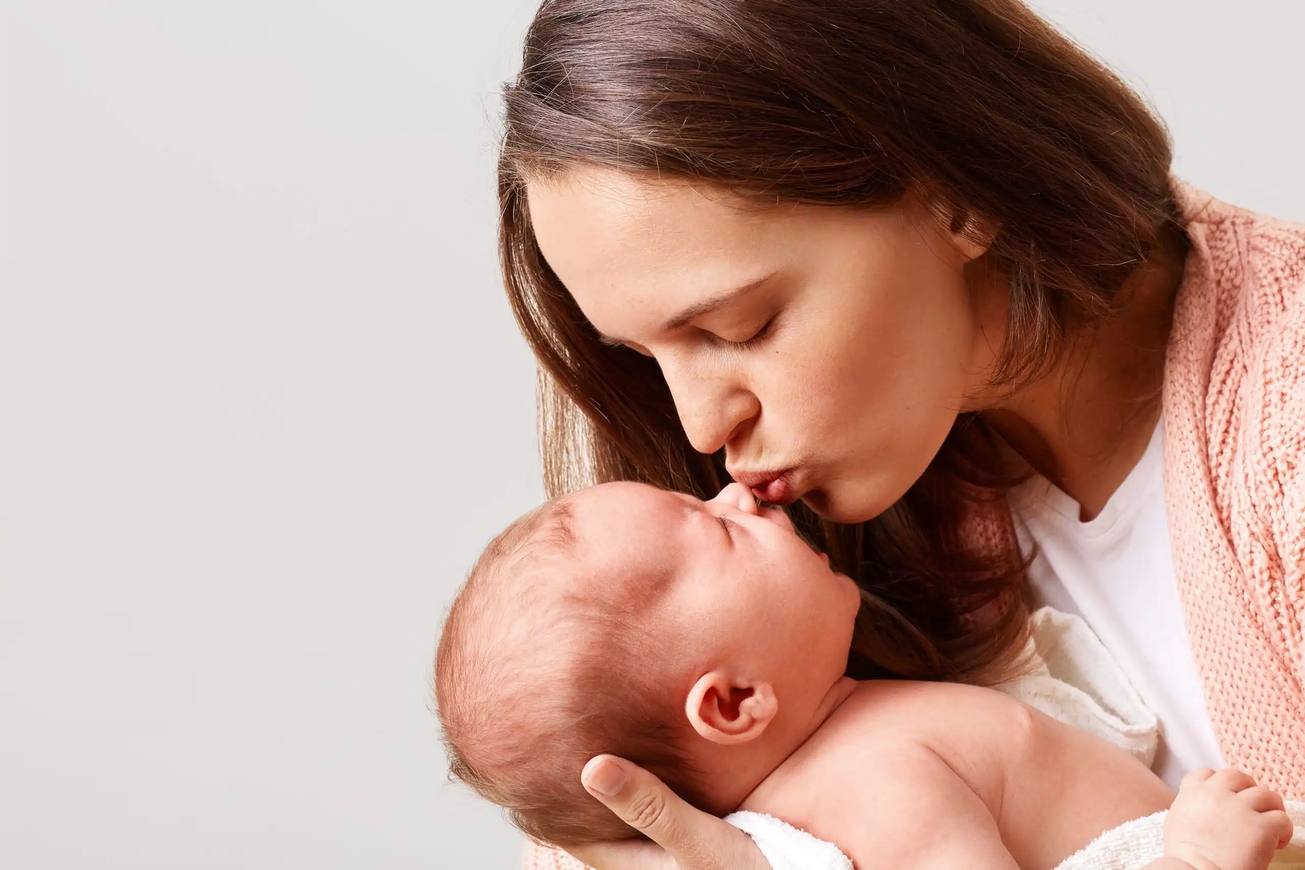 Mother lovingly kisses newborn baby after successful ivf treatment